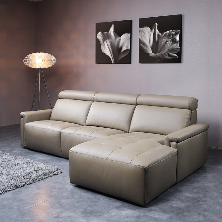 Beige sectional sofa in a living room with wall art and floor lamp.