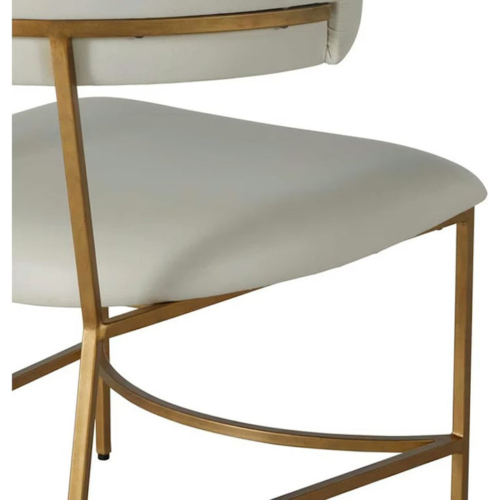 Close-up of a chair with white cushioned seat and gold metal frame on a white background