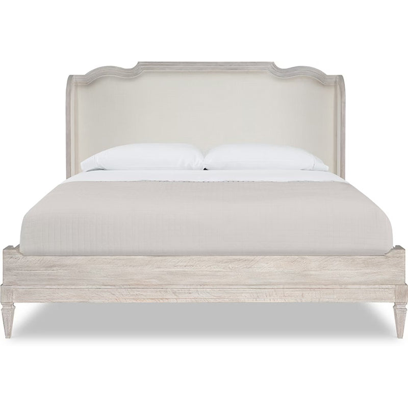 Beige upholstered bed with white bedding on a white background