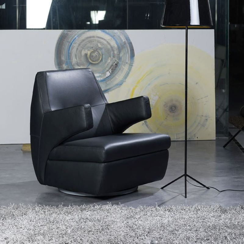 Black leather armchair in a modern room with abstract art on the wall.
